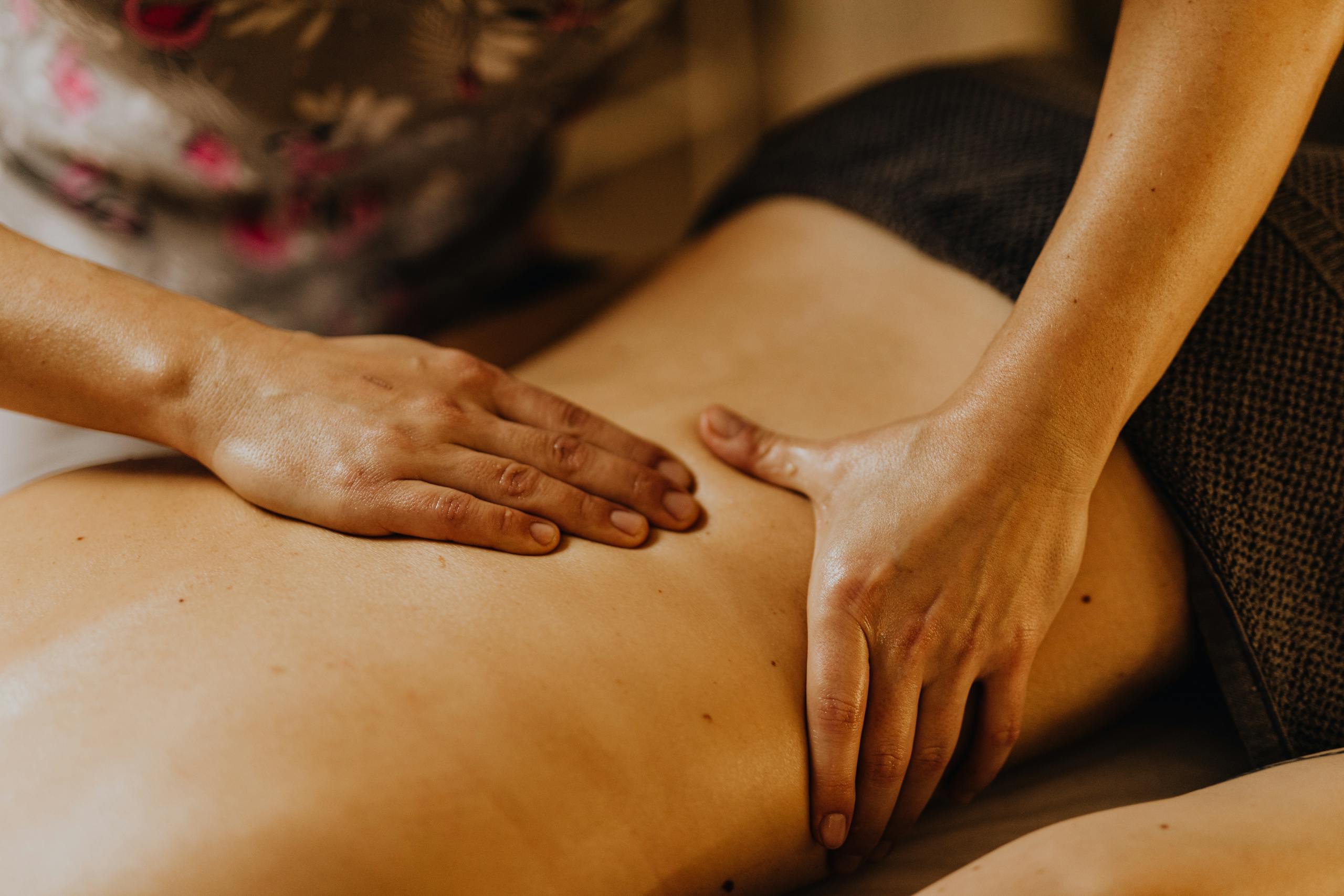 Close-up of hands giving a soothing back massage in a calm atmosphere.